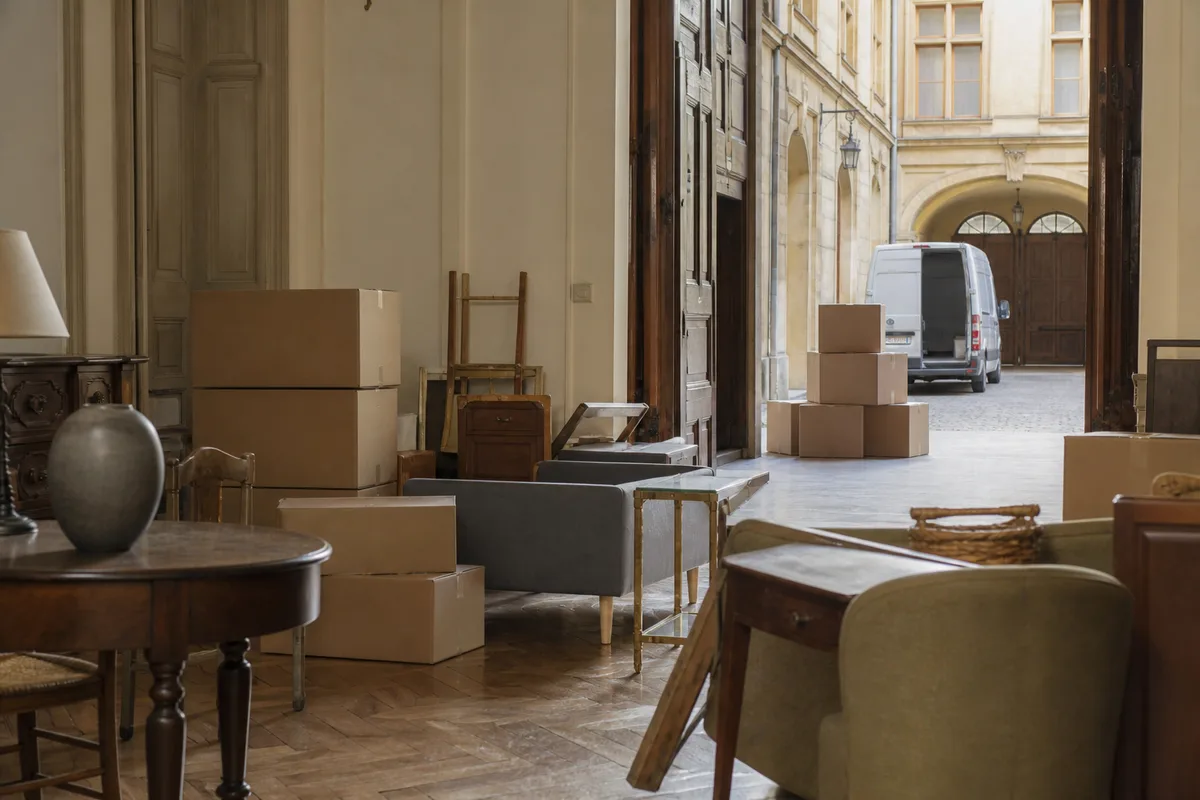 Salon d&rsquo;un appartement ancien encombré de meubles et de cartons avant enlèvement